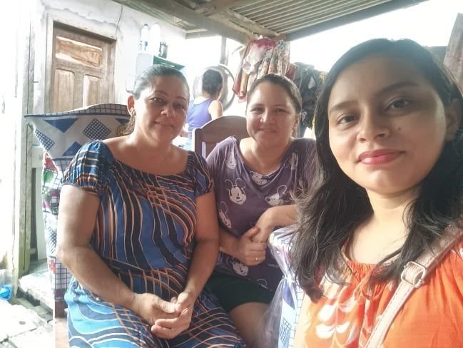 Três mulheres sorrindo para uma selfie numa varanda