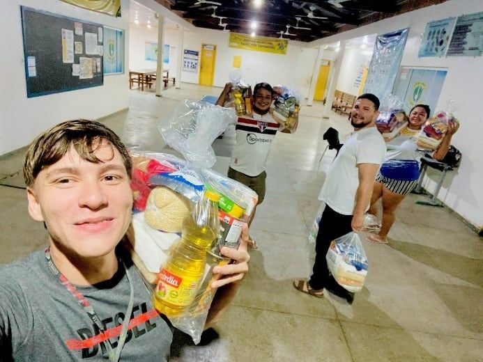 Jovem segurando sacolas de alimentos numa sala