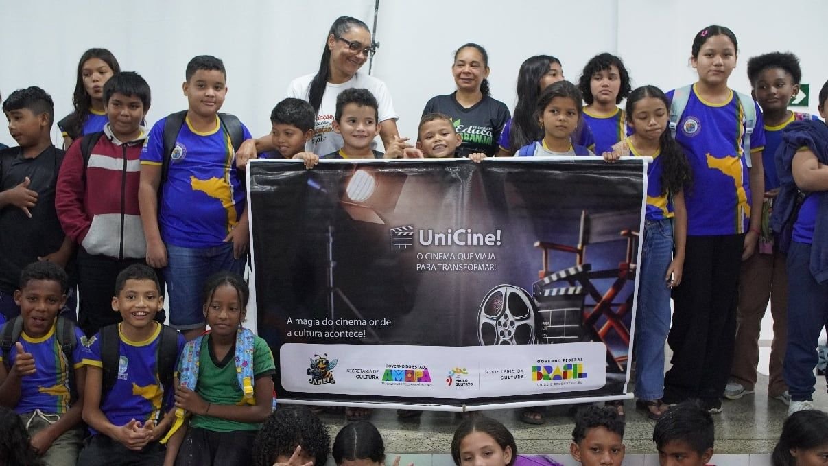 Turma de estudantes posando com o banner do UniCine