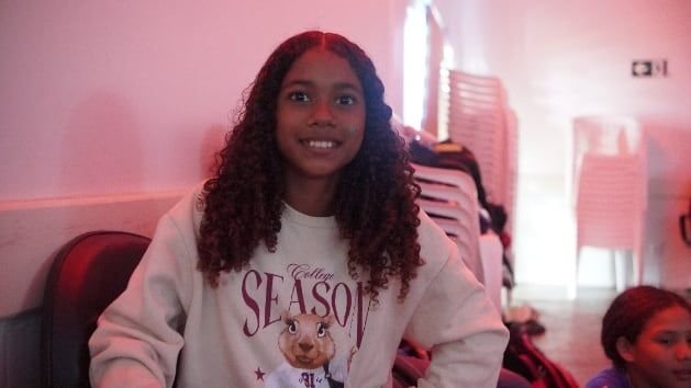 Menina sorrindo numa sala de exibição