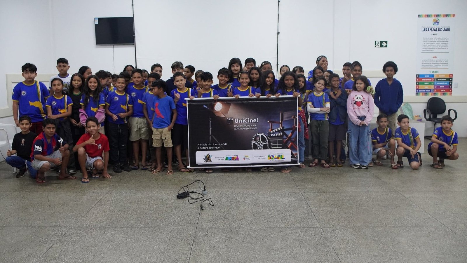 Grupo de estudantes posando com o banner do UniCine